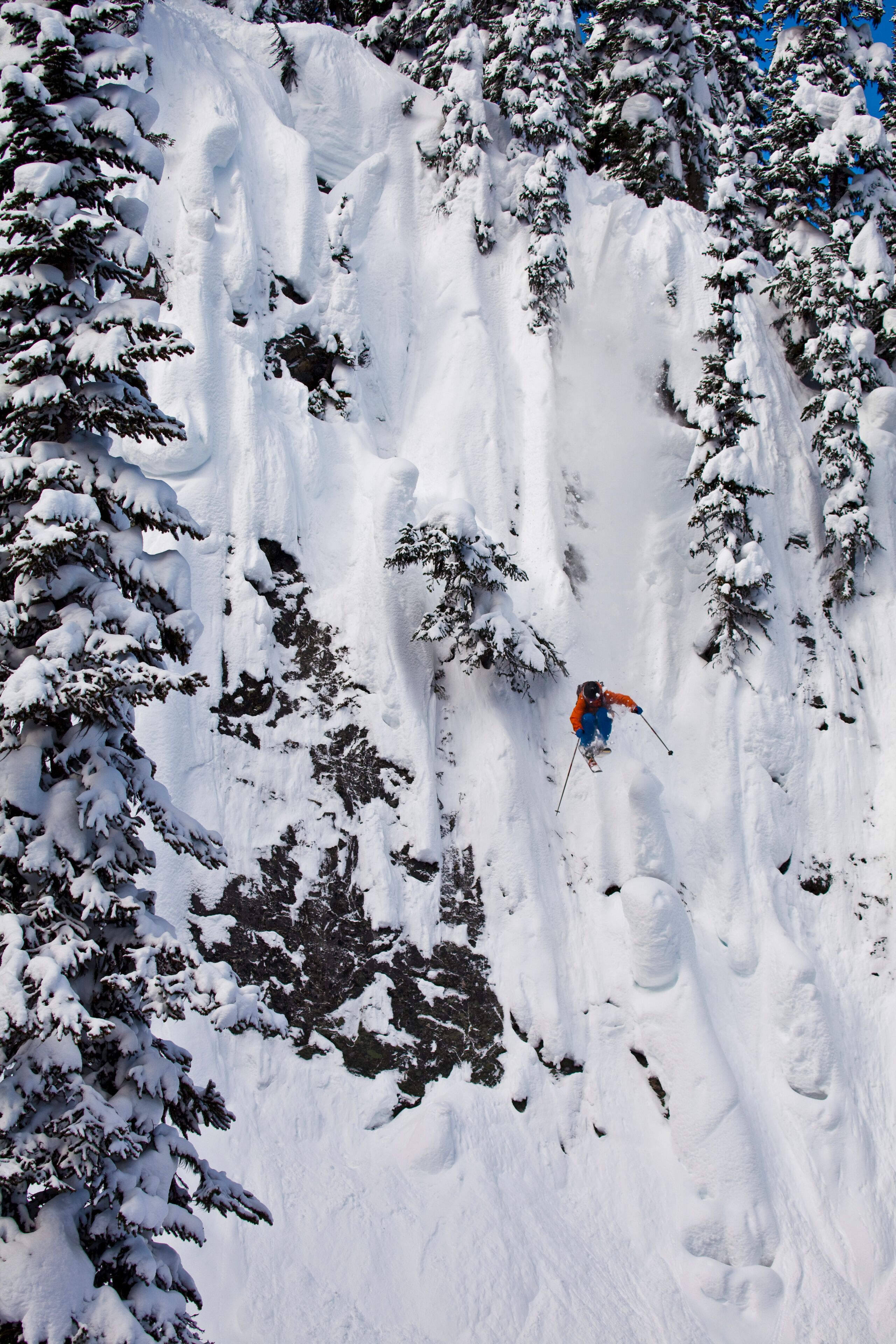 A male freeskier drops a huge cliff at Revelstoke Mtn Resort, BC