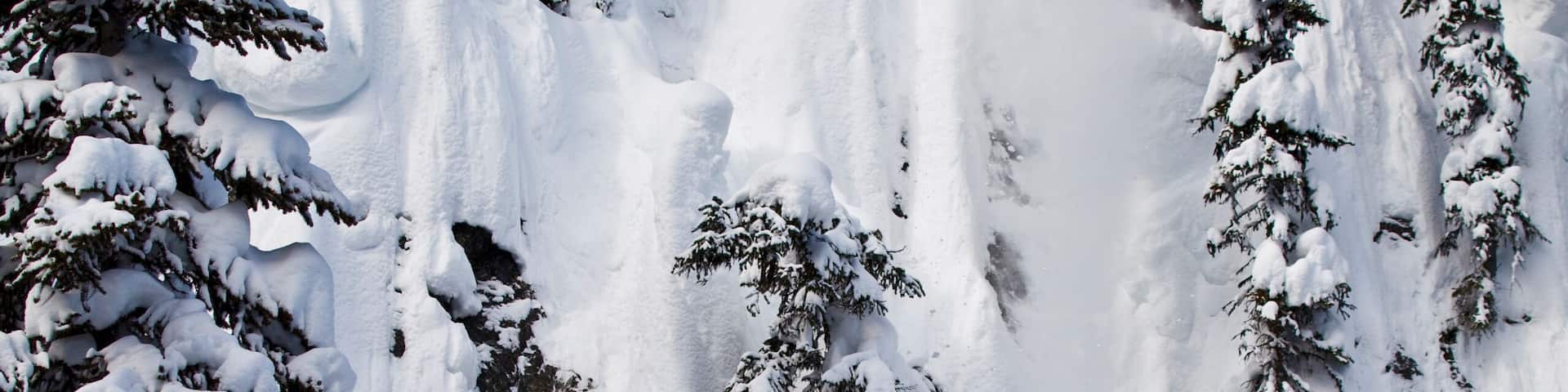 A male freeskier drops a huge cliff at Revelstoke Mtn Resort, BC