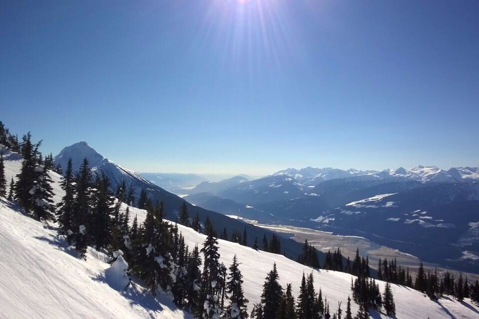 A snow-covered mountain range with a clear sky and a prominent peak.