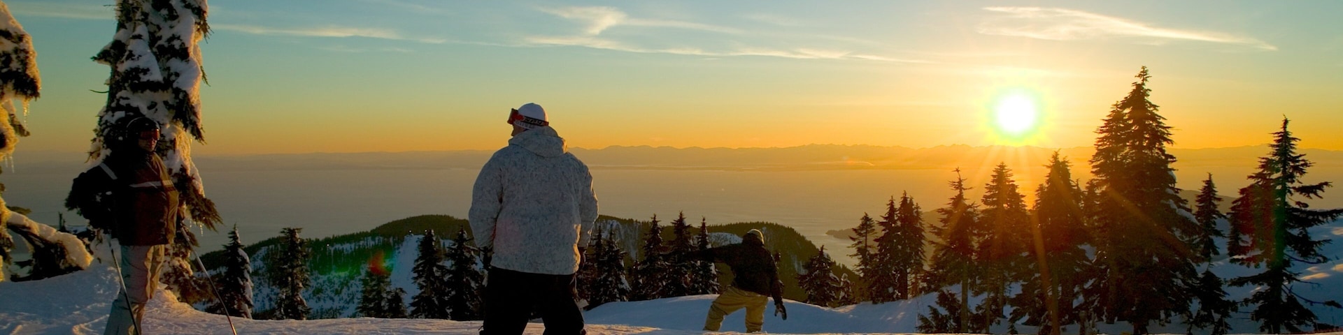 Cypress Mountain que incluye montañas, snowboard y un atardecer