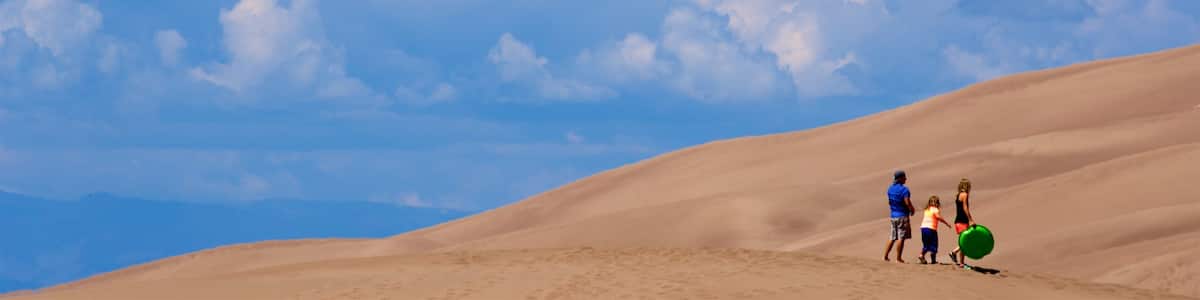 Great Sand Dunes National Park featuring desert views as well as a family