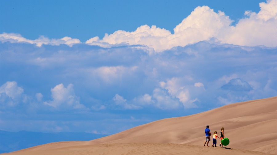 Great Sand Dunes National Park featuring desert views as well as a family