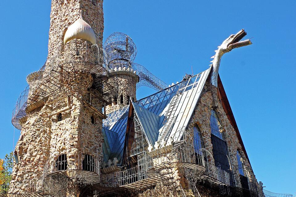 Una torre de pedra amb teulada metàl·lica i una gran escultura de metall.