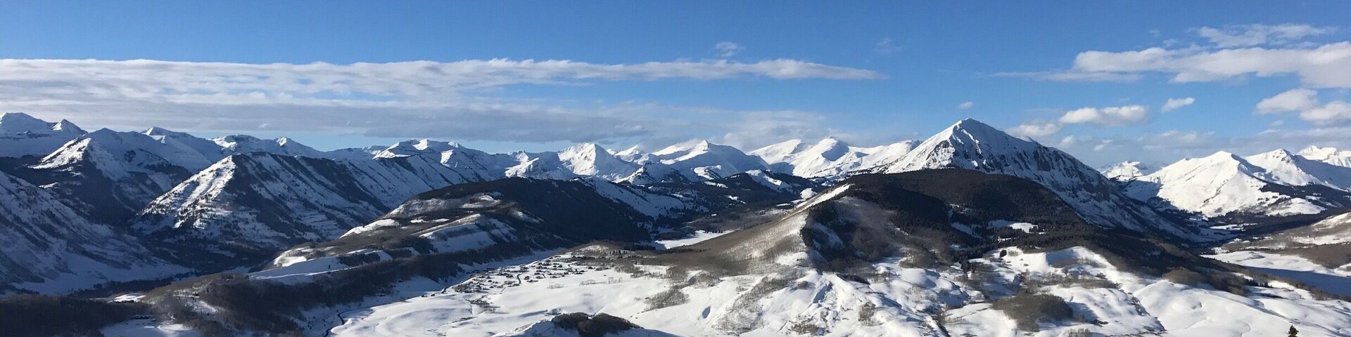 Una cadena montañosa cubierta de nieve con un pueblo en el valle.