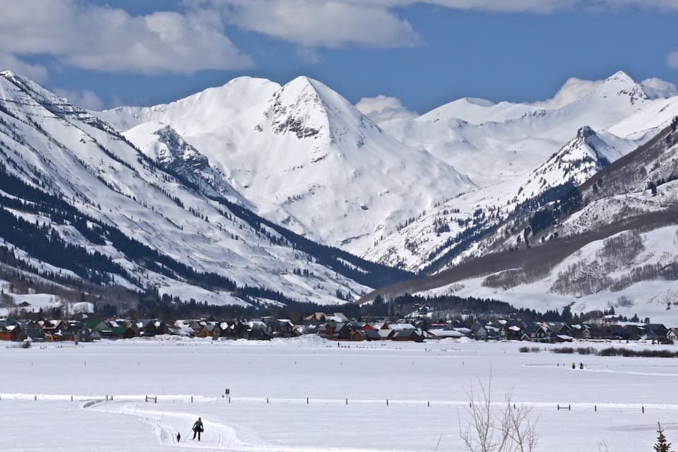 A snow-covered mountain range with a town nestled in a valley.
