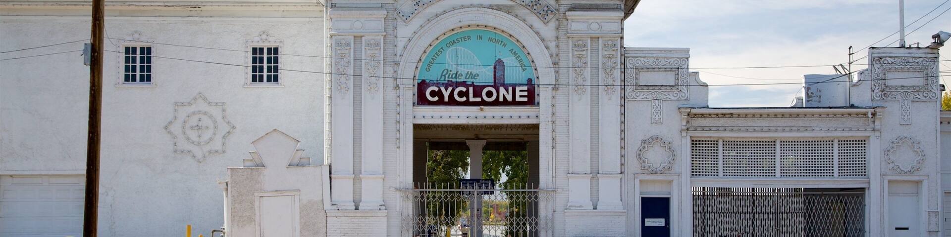 A white building with a sign that reads "Cyclone" and a roller coaster graphic.