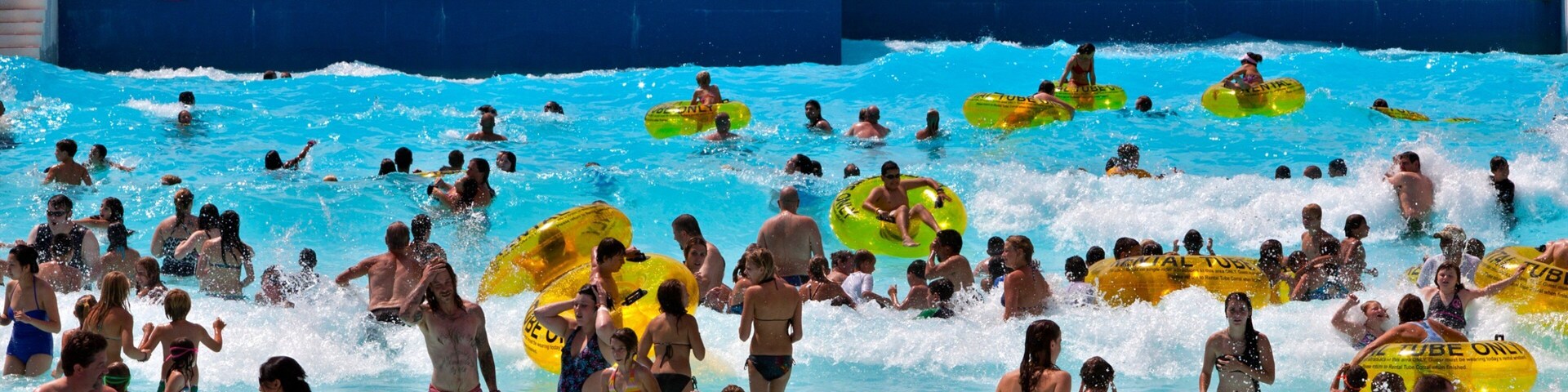 Water World showing waves and a waterpark as well as a large group of people