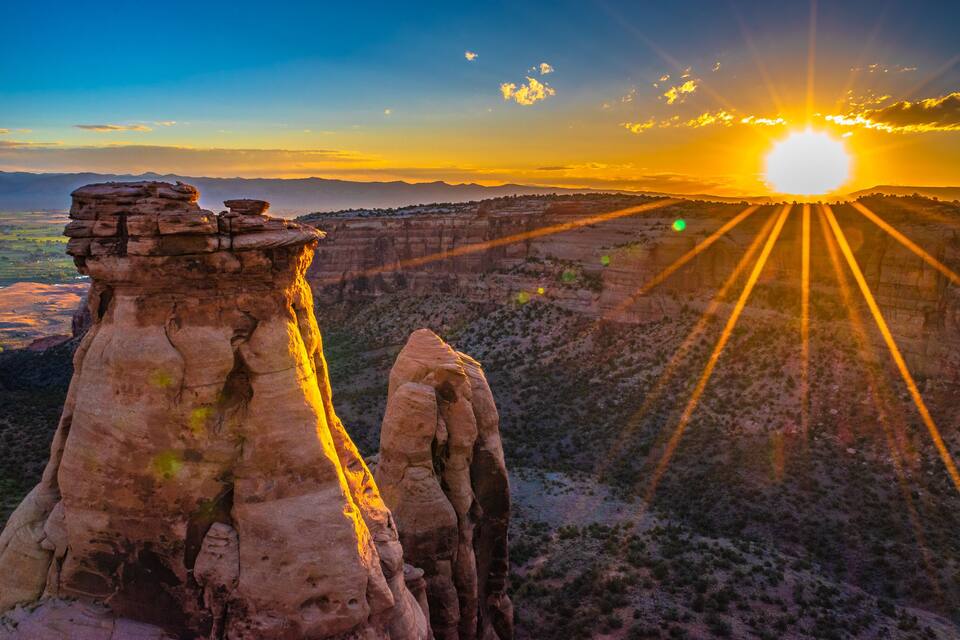 A rock formation at sunset with rays of sunlight.