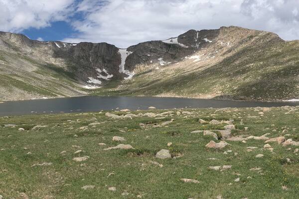 Un paysage de montagne avec un lac et un terrain rocheux.