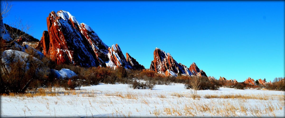 #BestOf5
This park is completely breathtaking year round. There are different paths with varying difficulties.The gorgeous red rock formations jut out all around you, making for an enchanting hike.   A seven dollar entrance fee for the day, and no dogs allowed. Well worth the very short drive up from Denver.
The stark contrast of the red rocks and the white snow makes for a colorful hike.