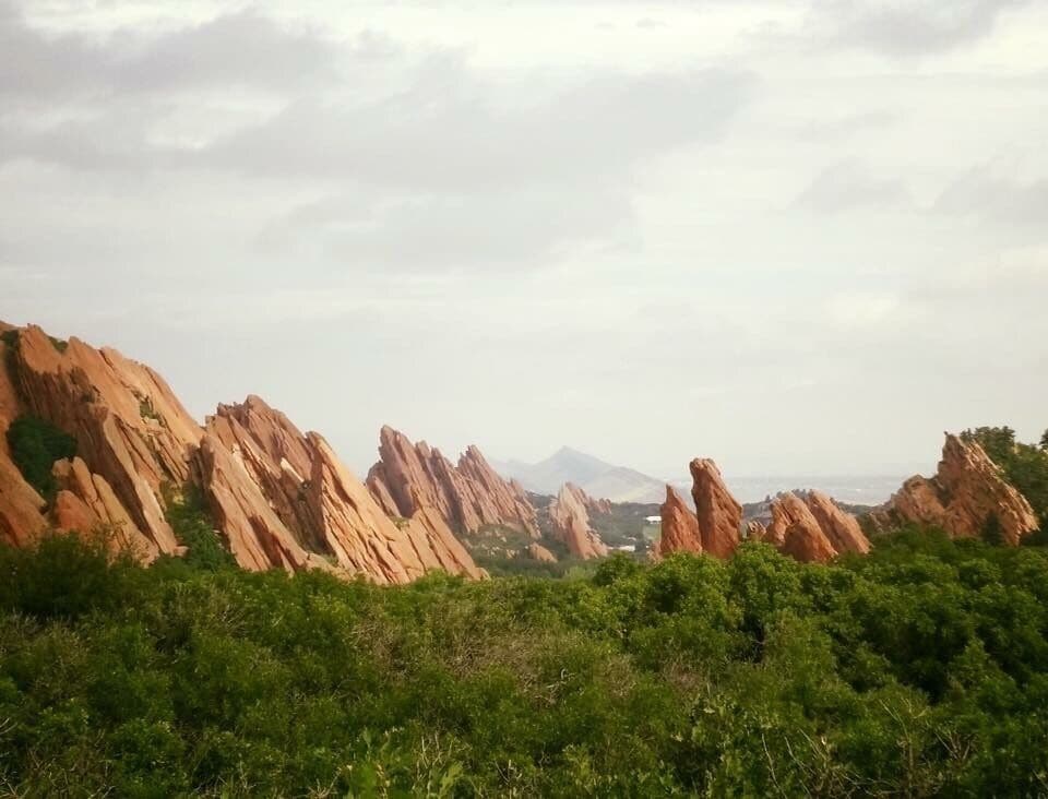 A landscape with red rock formations and green vegetation.