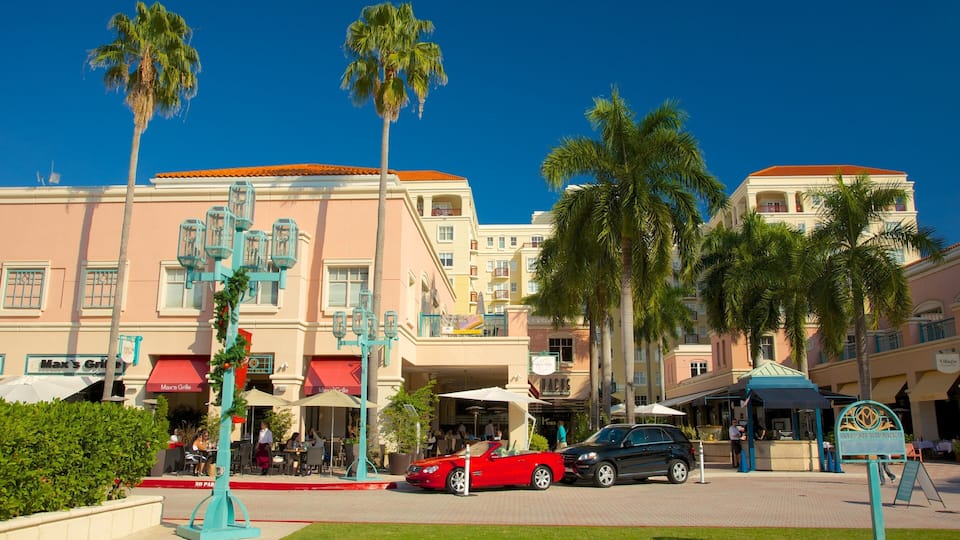 Vibrant atmosphere in Mizner Park featuring palm trees, outdoor dining, and luxury cars in Boca Raton, Florida