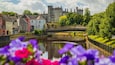Kilkenny Castle which includes flowers, a river or creek and a small town or village