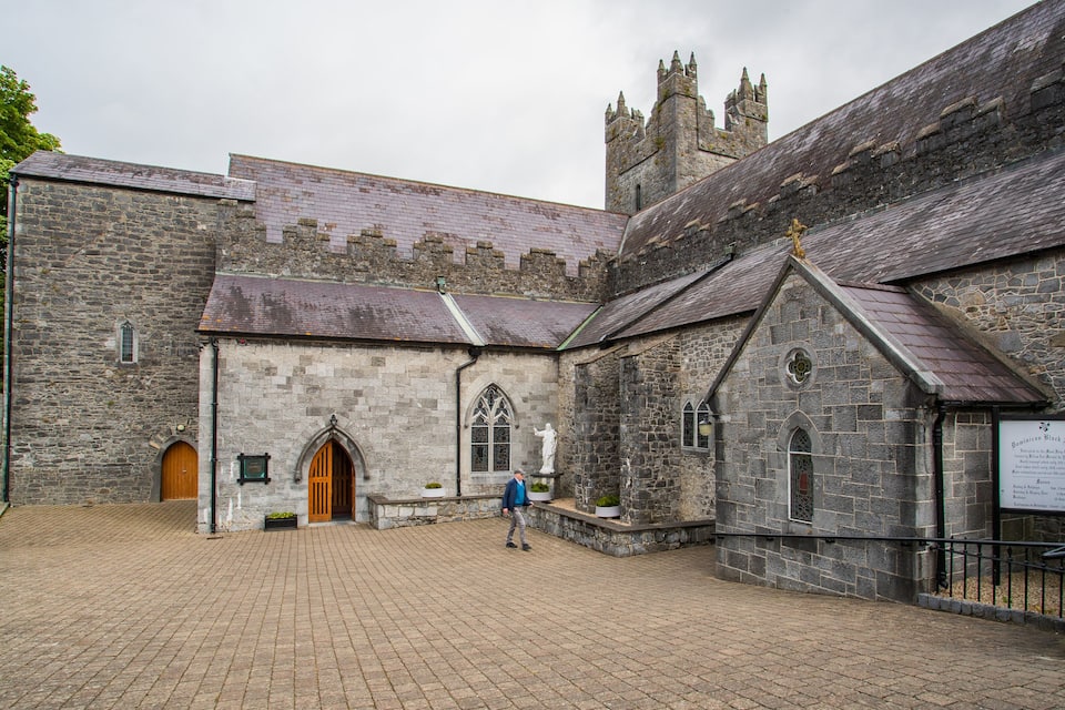 A historic stone building with a large arched entrance and a clock tower.