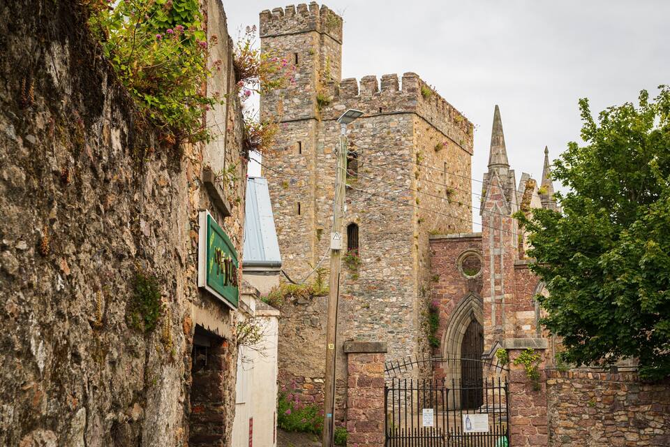 A historic stone building with a tower and arched windows.