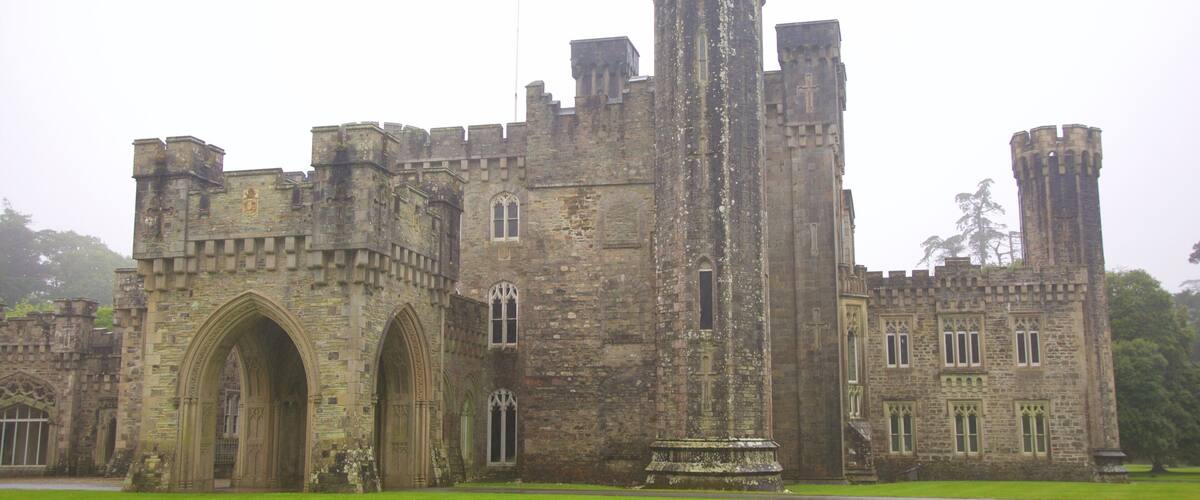A large stone castle with multiple towers and arched windows.