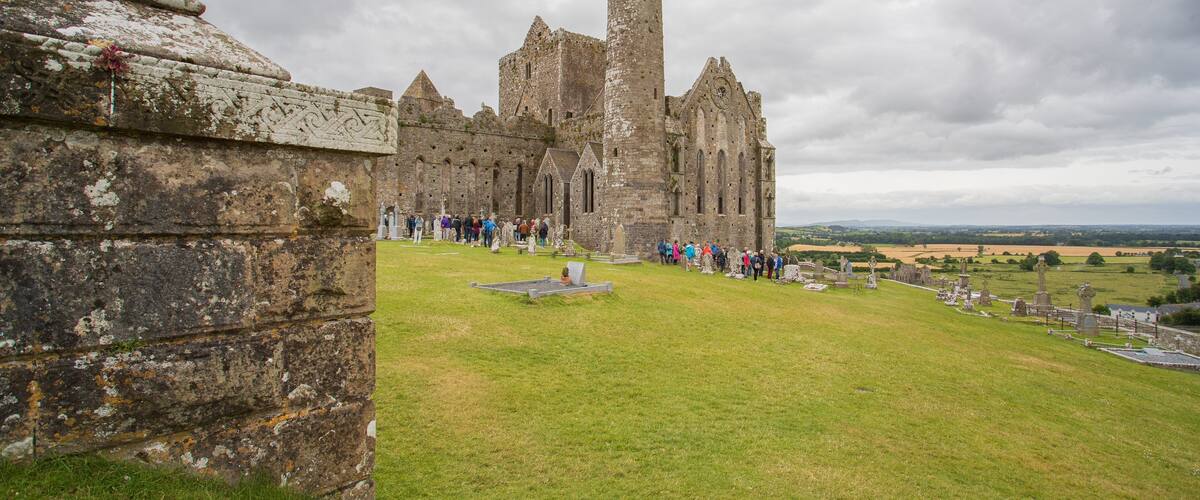 Rock of Cashel featuring heritage architecture and chateau or palace as well as a small group of people