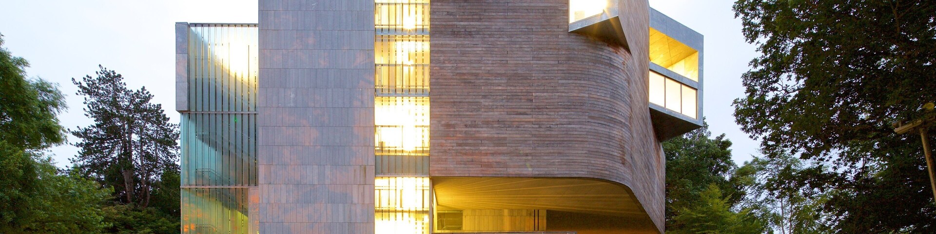Un edificio moderno con fachada curva y ventanas grandes.