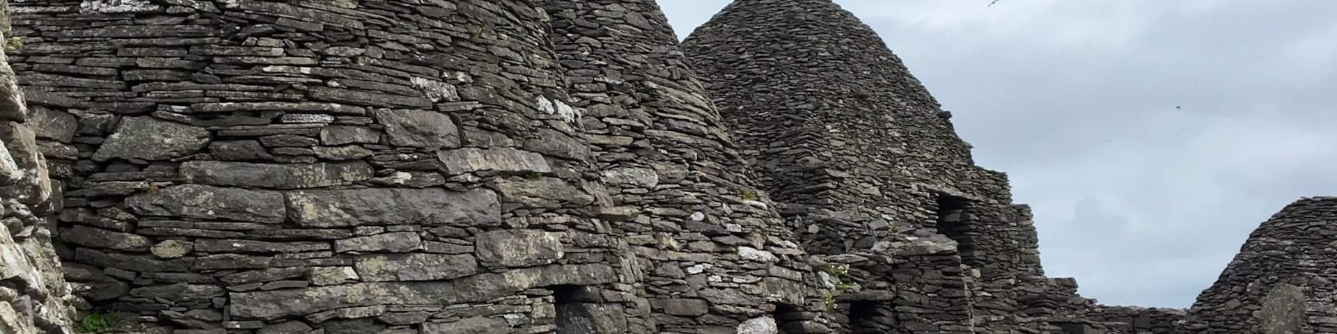 Ancient stone ruins with layered walls and a rocky shoreline.