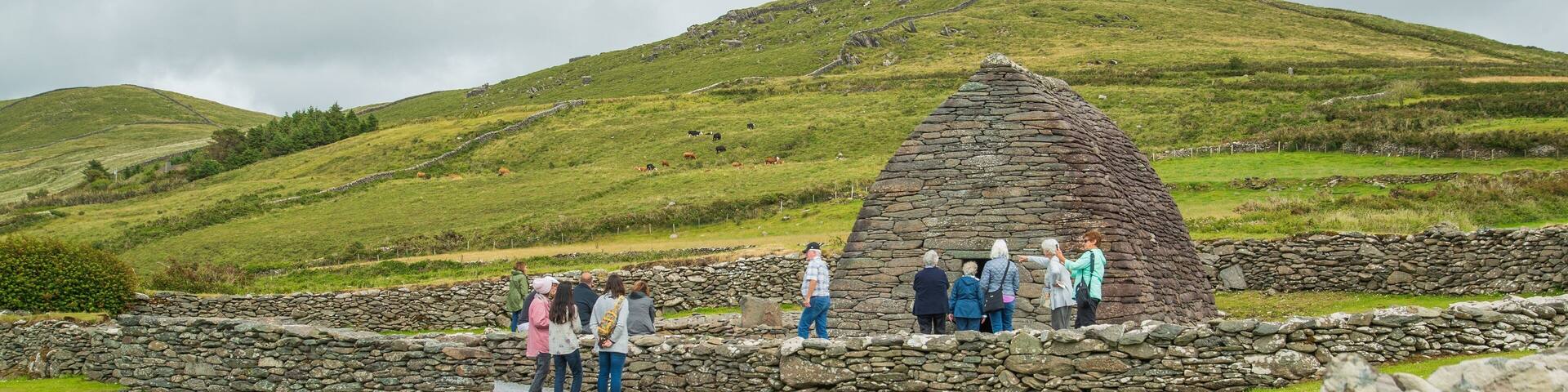 Gallarus Oratory featuring tranquil scenes and heritage architecture as well as a small group of people
