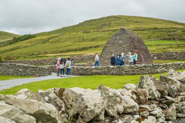 Gallarus Oratory featuring tranquil scenes and heritage architecture as well as a small group of people