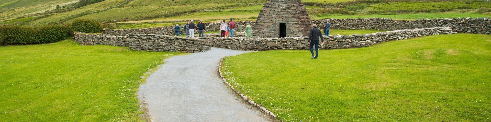 Gallarus Oratory featuring heritage elements and mountains as well as a small group of people