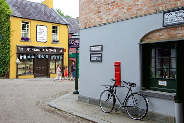 ChĂąteau et parc de Bunratty montrant signalisation et scĂšnes de rue aussi bien que petit groupe de personnes