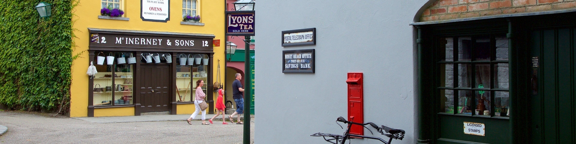 Bunratty Castle and Folk Park featuring street scenes and signage as well as a small group of people