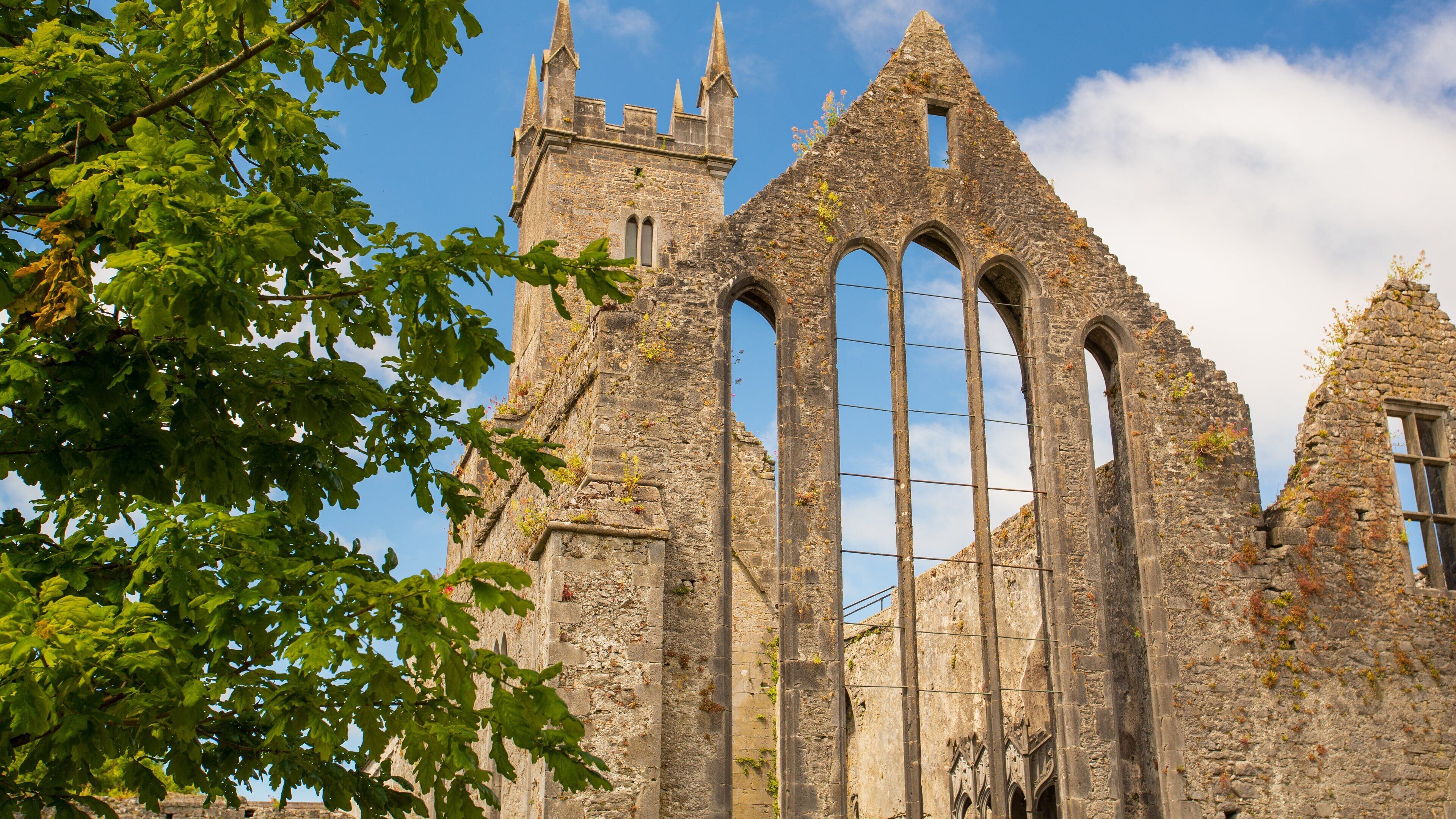 A historic stone building with pointed arches and a tower.