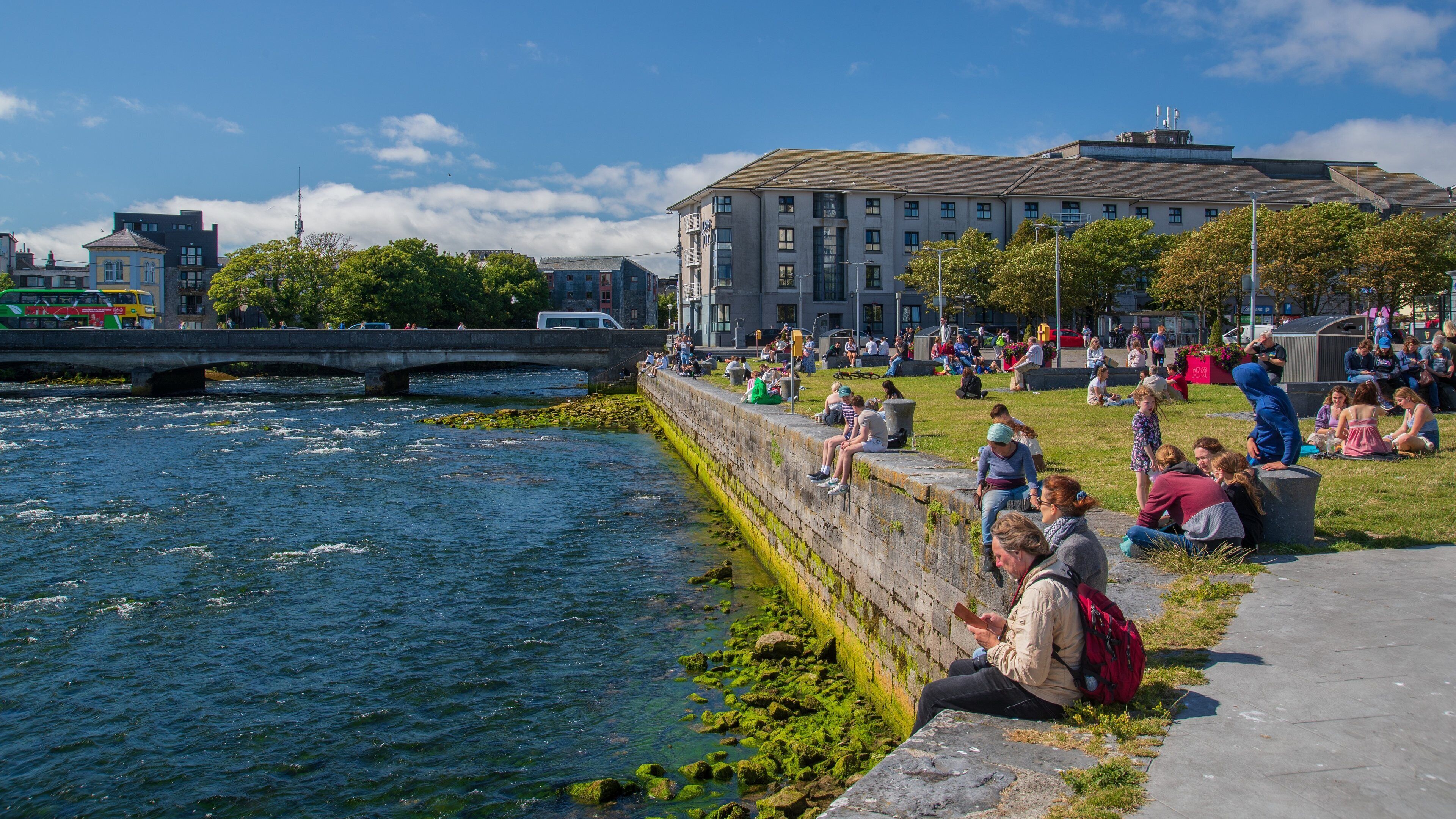 Spanish Arch showing a park and a bay or harbor as well as a large group of people