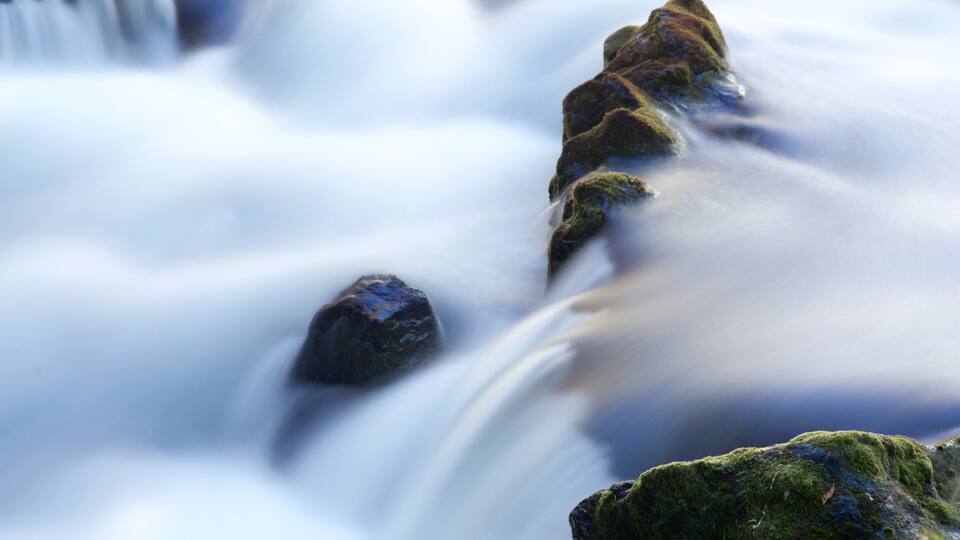 A waterfall with moss-covered rocks.