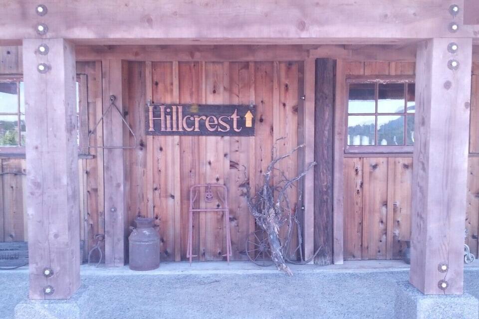 A wooden building with a sign that reads "Hillcrest" and a bicycle leaning against it.