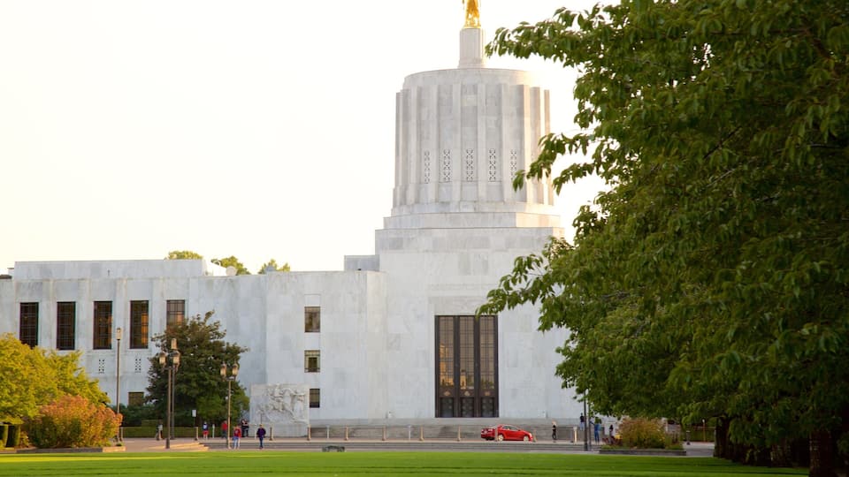 A large white building with a tall tower and a statue on top.