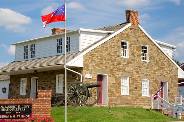 Un bâtiment historique à la façade en pierre, un mât avec un drapeau, un canon et une enseigne indiquant qu'il s'agit du musée et de la boutique de souvenirs du quartier général du général Robert E. Lee.