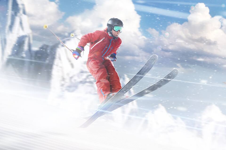 A skier in a red suit on a snowy slope with clouds in the sky.