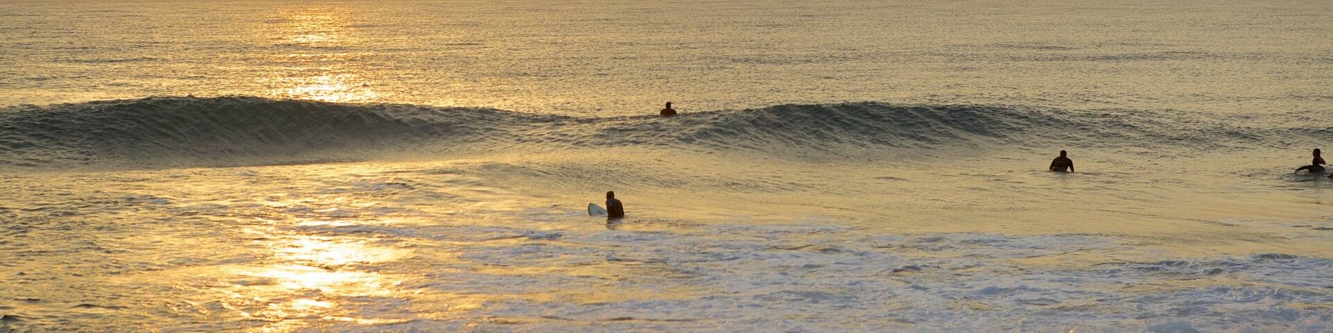 South Beach mostrando surfe, ondas e um pôr do sol