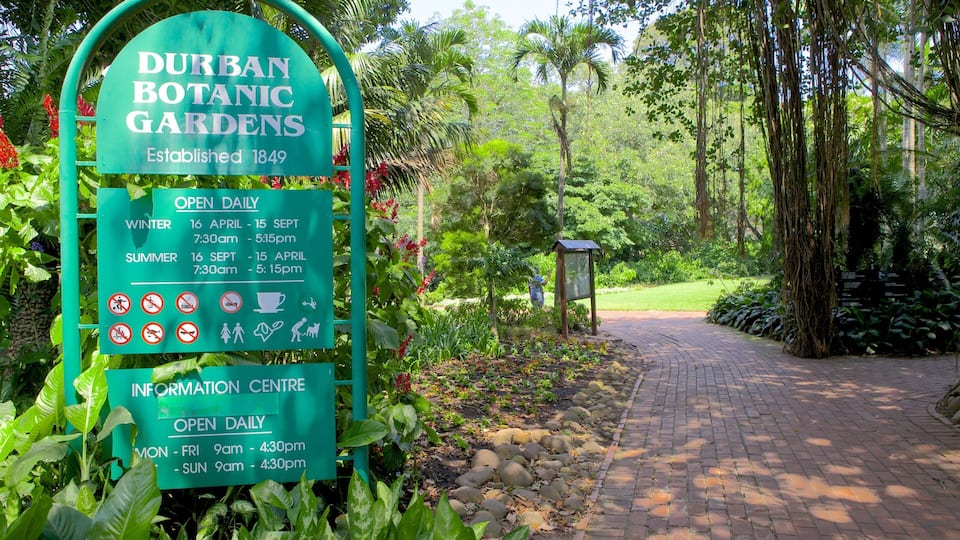 A sign for Durban Botanic Gardens with opening hours and a pathway leading into the garden.