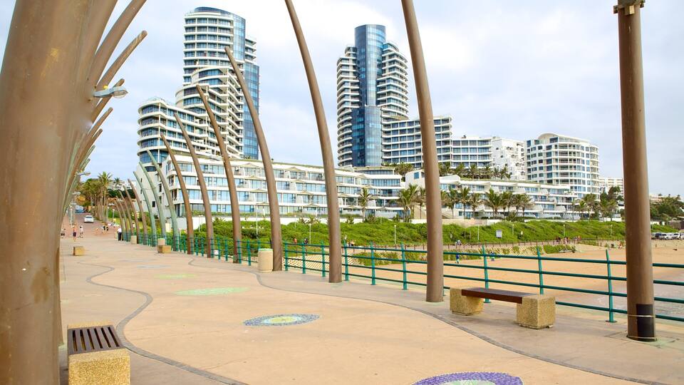 A promenade with modern high-rise buildings in the background.