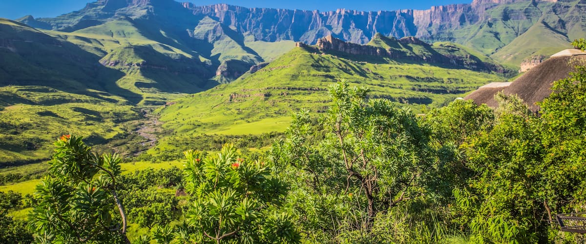 A mountainous landscape with green valleys and rocky cliffs.