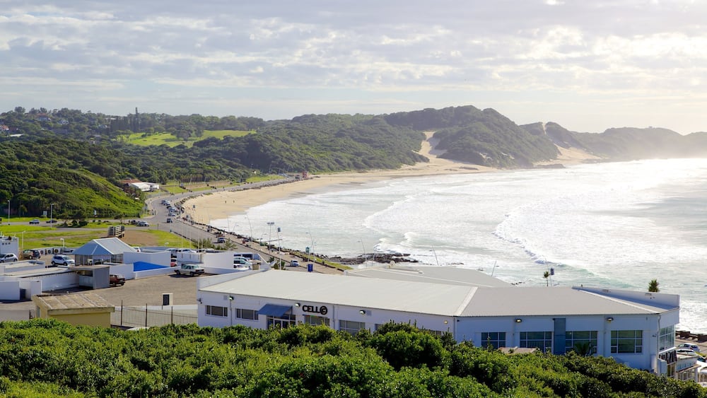 Une ville côtière avec une plage, un parking et des bâtiments.