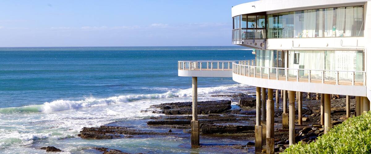 A coastal building with a balcony overlooking the ocean.