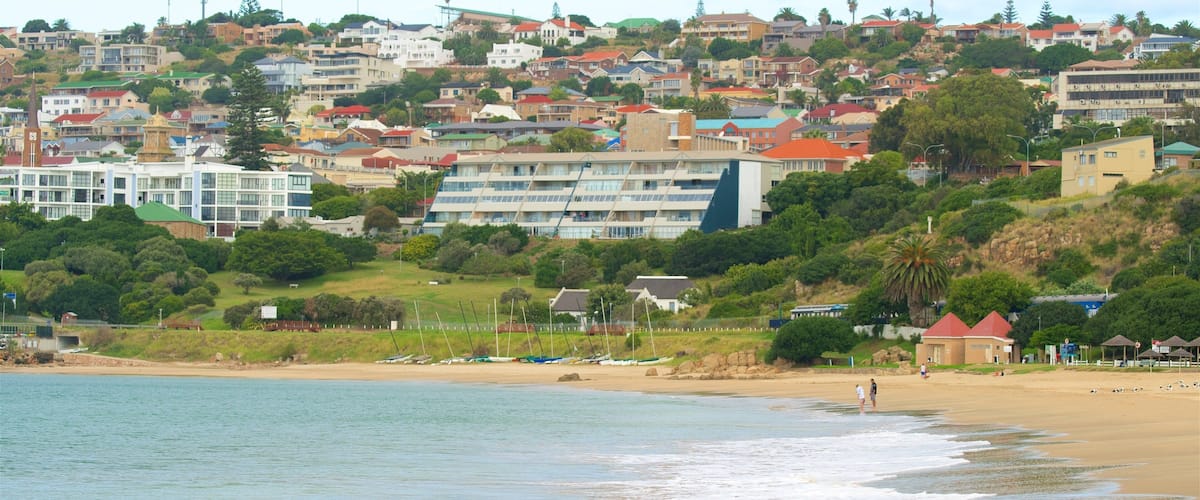 A coastal town with a beach, boats, and residential buildings.