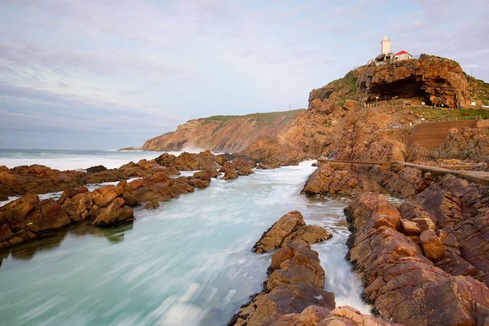 Une côte rocheuse avec un phare perché sur une falaise.