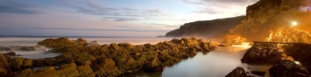 Cape St. Blaize Lighthouse showing rugged coastline and a sunset