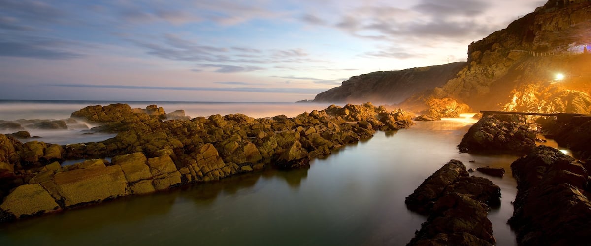Cape St. Blaize Lighthouse showing rugged coastline and a sunset