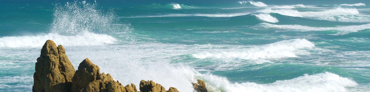 A rocky coastline with waves crashing against the rocks.