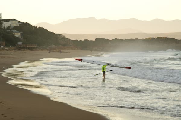 Plettenberg Bay Beach som viser surfing, en solnedgang og kajaksejlads eller kanosejlads