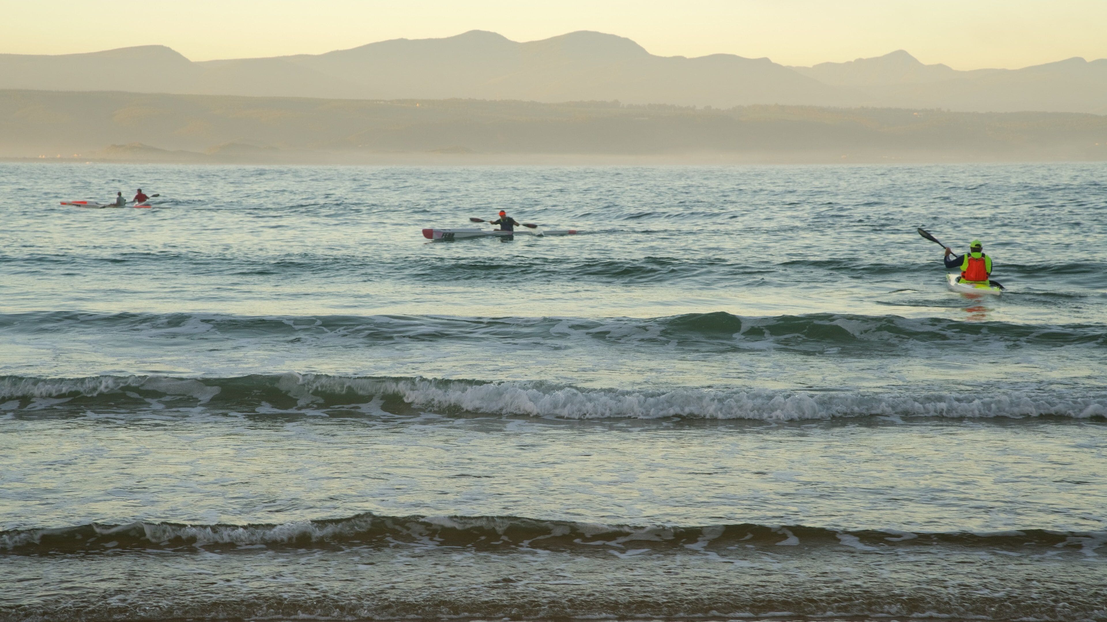 Plettenberg Bay Beach featuring a sandy beach and kayaking or canoeing as well as a small group of people