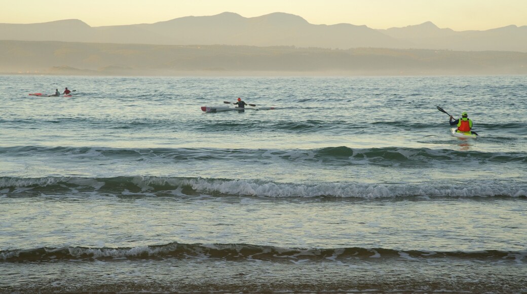 Plettenberg Bay Beach featuring a sandy beach and kayaking or canoeing as well as a small group of people