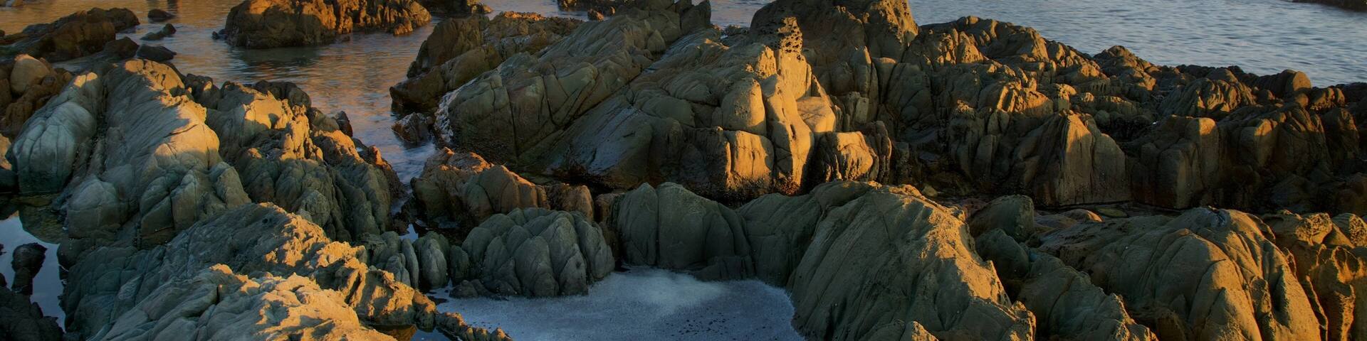 Kogel Bay Beach which includes a sunset and a pebble beach